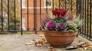Vaso di fiori autunnali colorati su un balcone, con foglie cadute intorno
